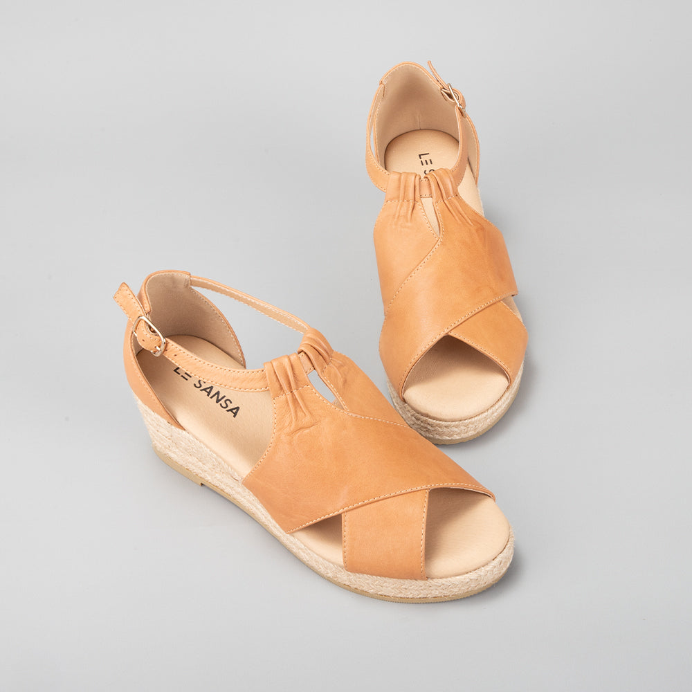 Le Sansa Pernia tan/tan sandals with open toes and ankle straps, featuring a sleek design and comfortable flat sole.