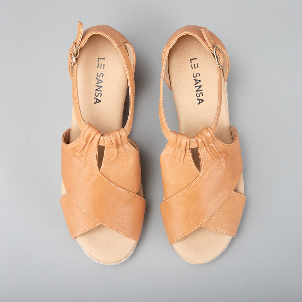 Le Sansa Pernia tan/tan sandals with open toes and ankle straps, featuring a stylish, casual design for warm weather wear.