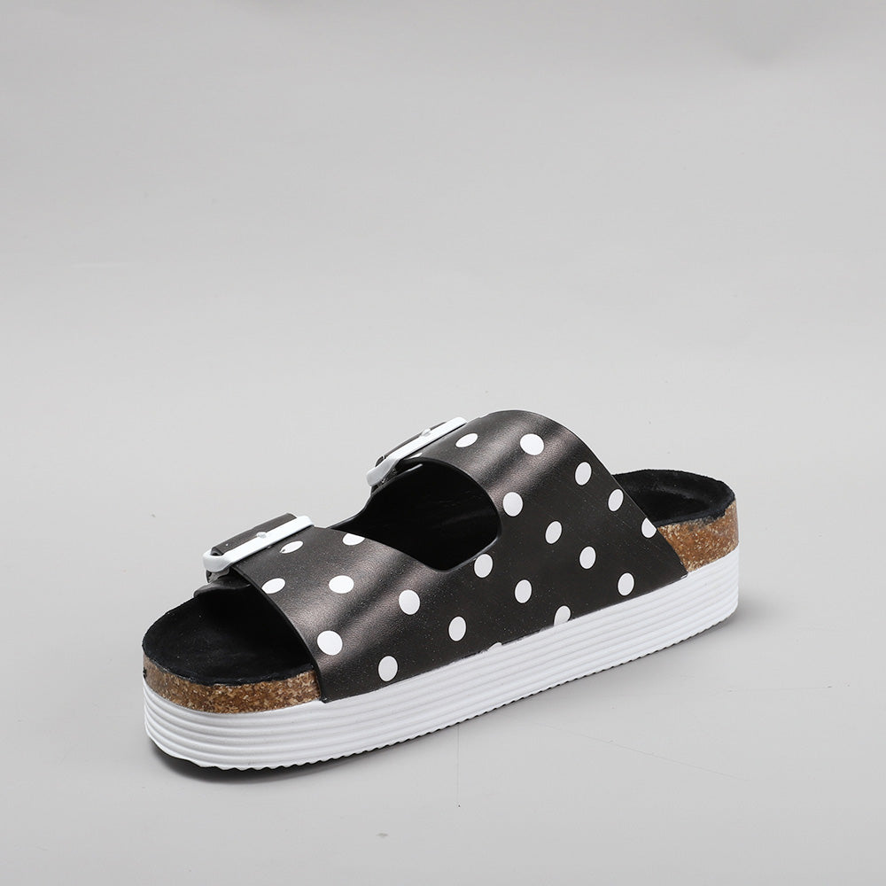 LE SANSA Duke black dot flats showing a stylish slip-on design with black polka dots on a dark background.
