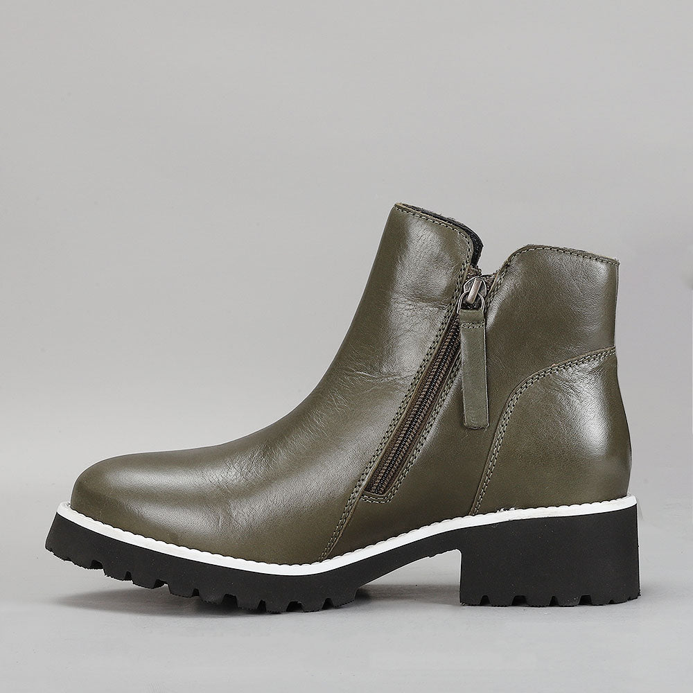 LE SANSA EAST OLIVE boots with tan leather straps and buckle details, styled on a mannequin.