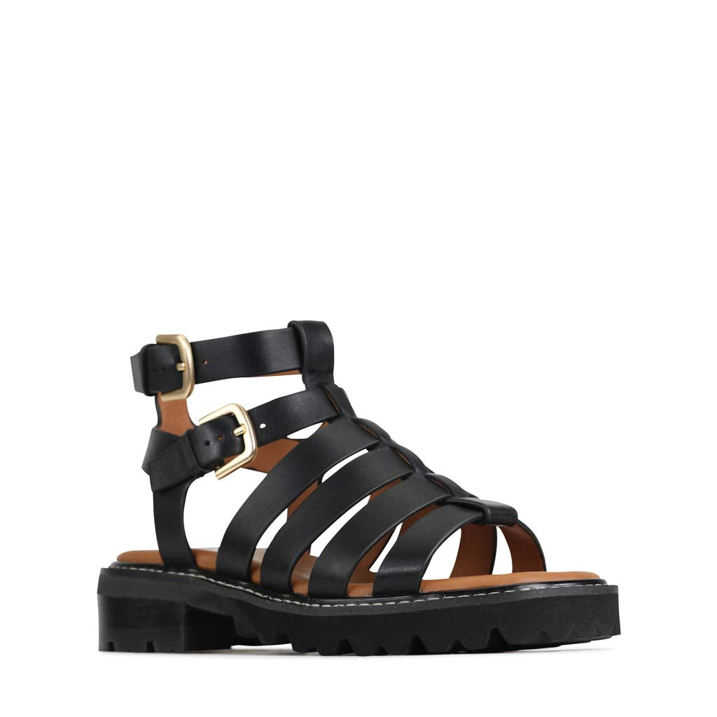 Eos Gizelle Black sandals with open toe design and ankle strap, stylish women's footwear in black leather.