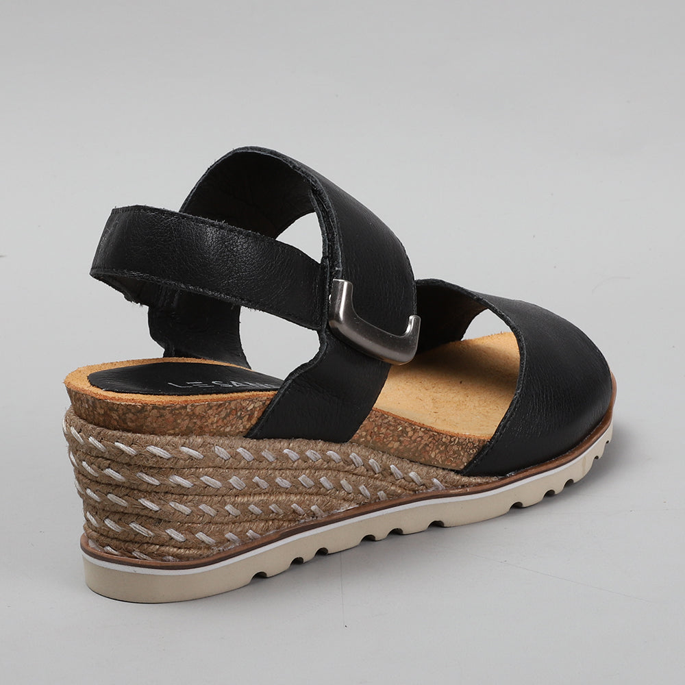 Le Sansa Evita black sandals with strap details, open-toe design, and flat sole, perfect for casual summer wear.