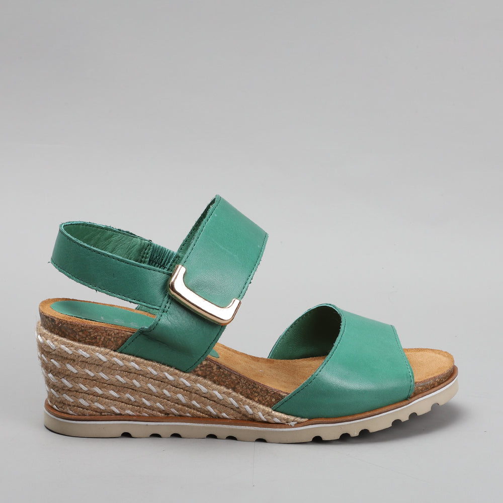 Le Sansa Evita Pine sandals featuring a stylish design with tan straps and comfortable flat soles.