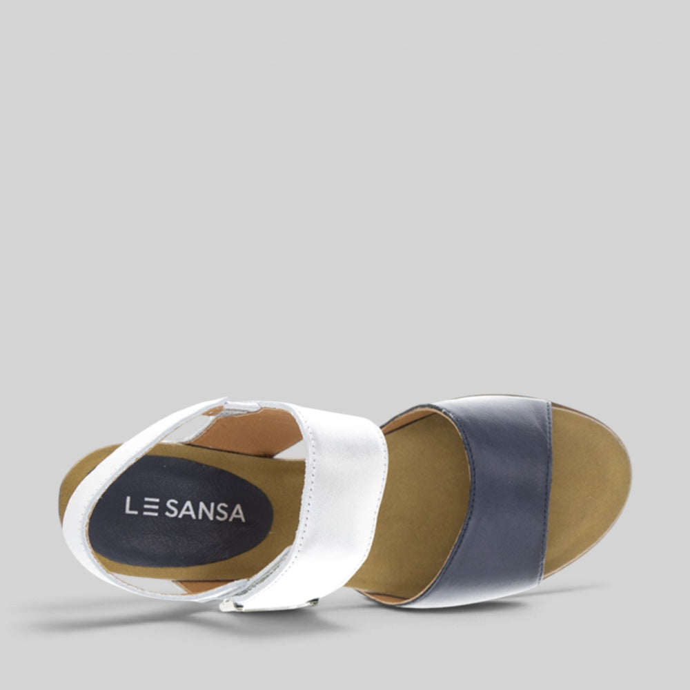 Le Sansa Evita Navy Silver sandals with straps and metallic accents, displayed on a neutral background.