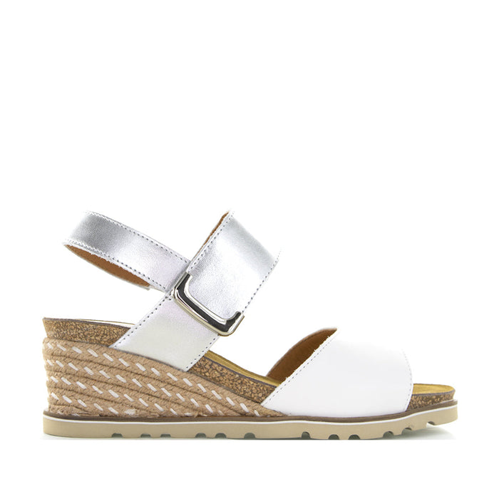 Le Sansa Evita white and silver sandals featuring elegant straps and a comfortable flat sole.