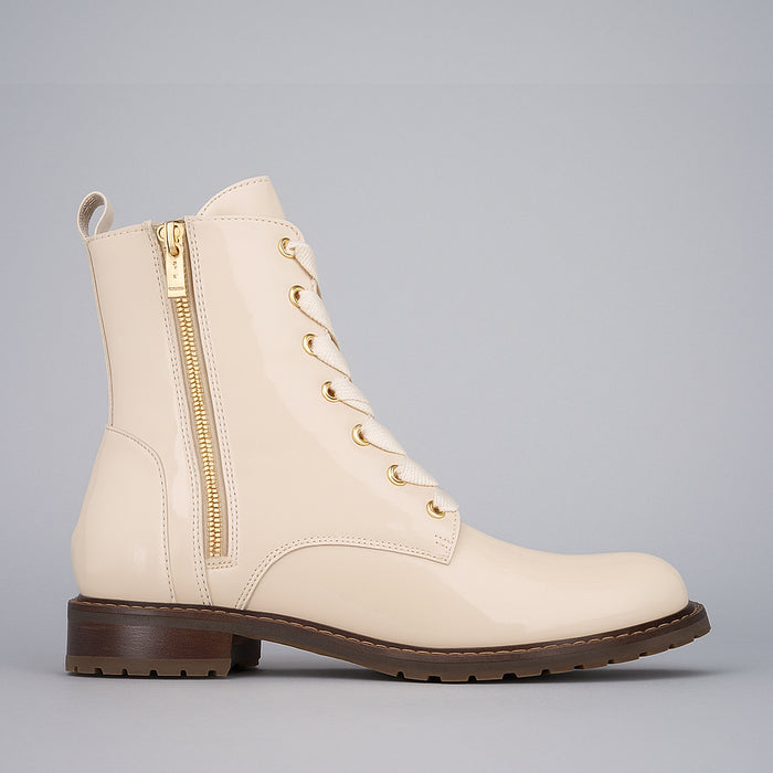 Le Sansa nude patent boots with sleek, shiny finish and pointed toes, styled with a low heel and elegant design.