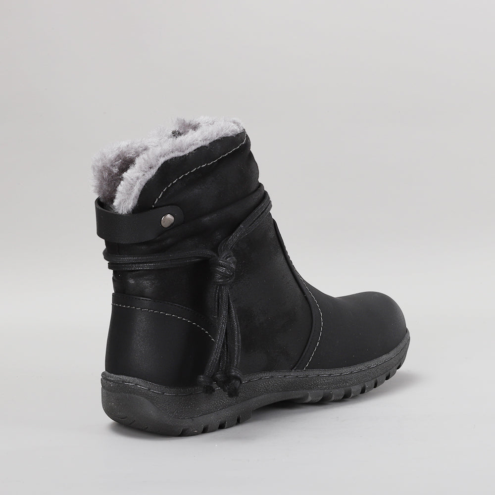 Black CC Resorts Gemma boots with ankle-high design and chunky heel, shown on a model in a casual outdoor setting.