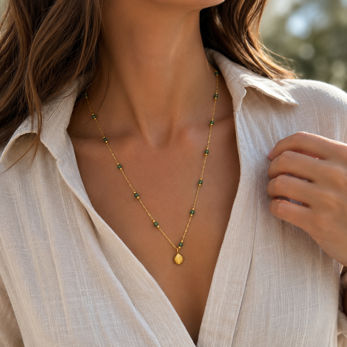 Golden sun charm necklace from Zeke Collection featuring a delicate chain and a radiant sun pendant.