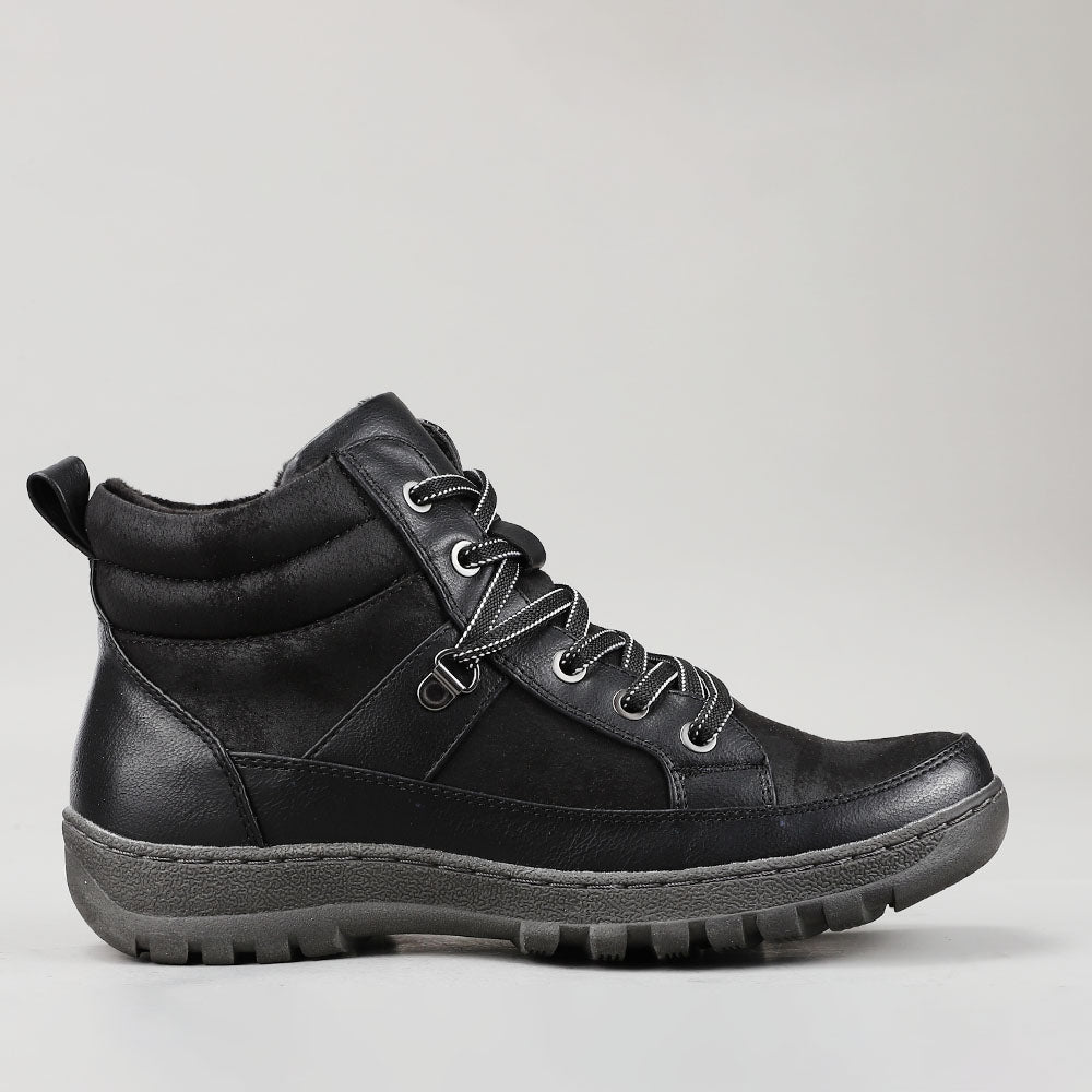 Black CC Resorts Gowan boots shown from the side, showcasing sleek design and ankle height.