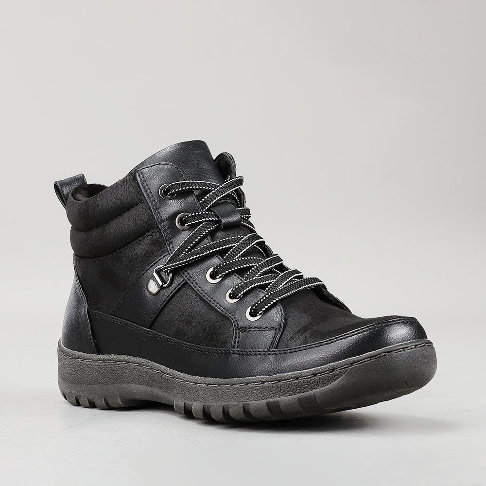 Black CC Resorts Gowan boots with a sleek design and ankle-high style, showcased in a side view image.