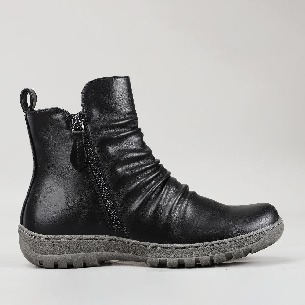 Black CC Resorts Greco boots shown from the side, featuring sleek design and ankle-high style with laces and sturdy sole.