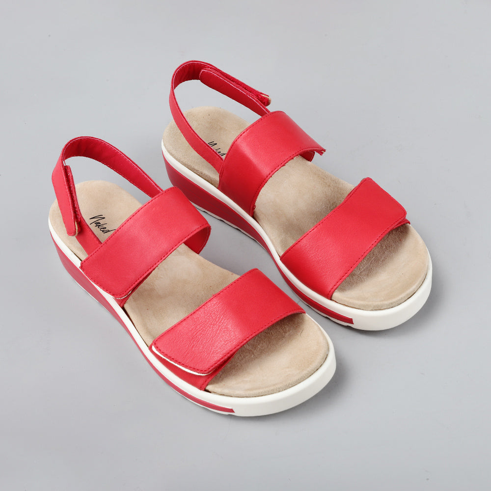 Pair of Naked Arches Hanza dark red sandals with open toes and adjustable straps, featuring a stylish and comfortable design.
