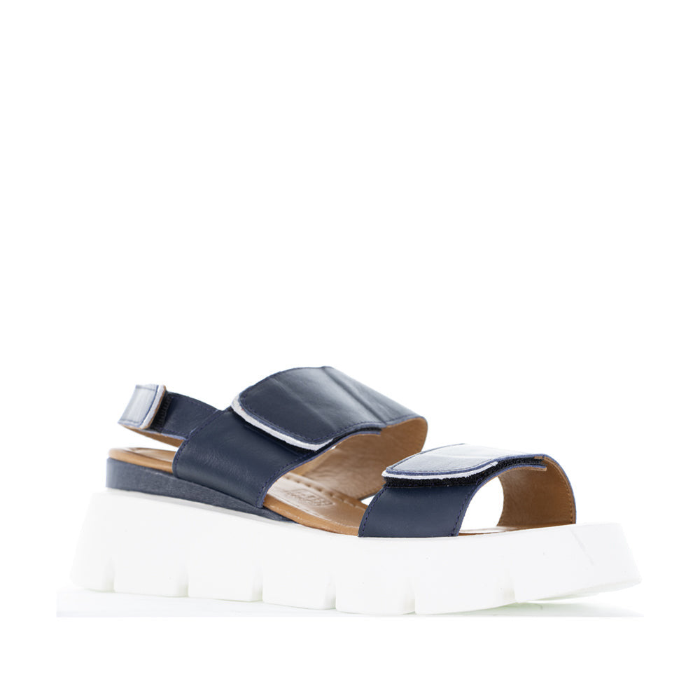 Le Sansa navy silver handle sandals with sleek straps and silver accents, perfect for casual or dressy occasions.