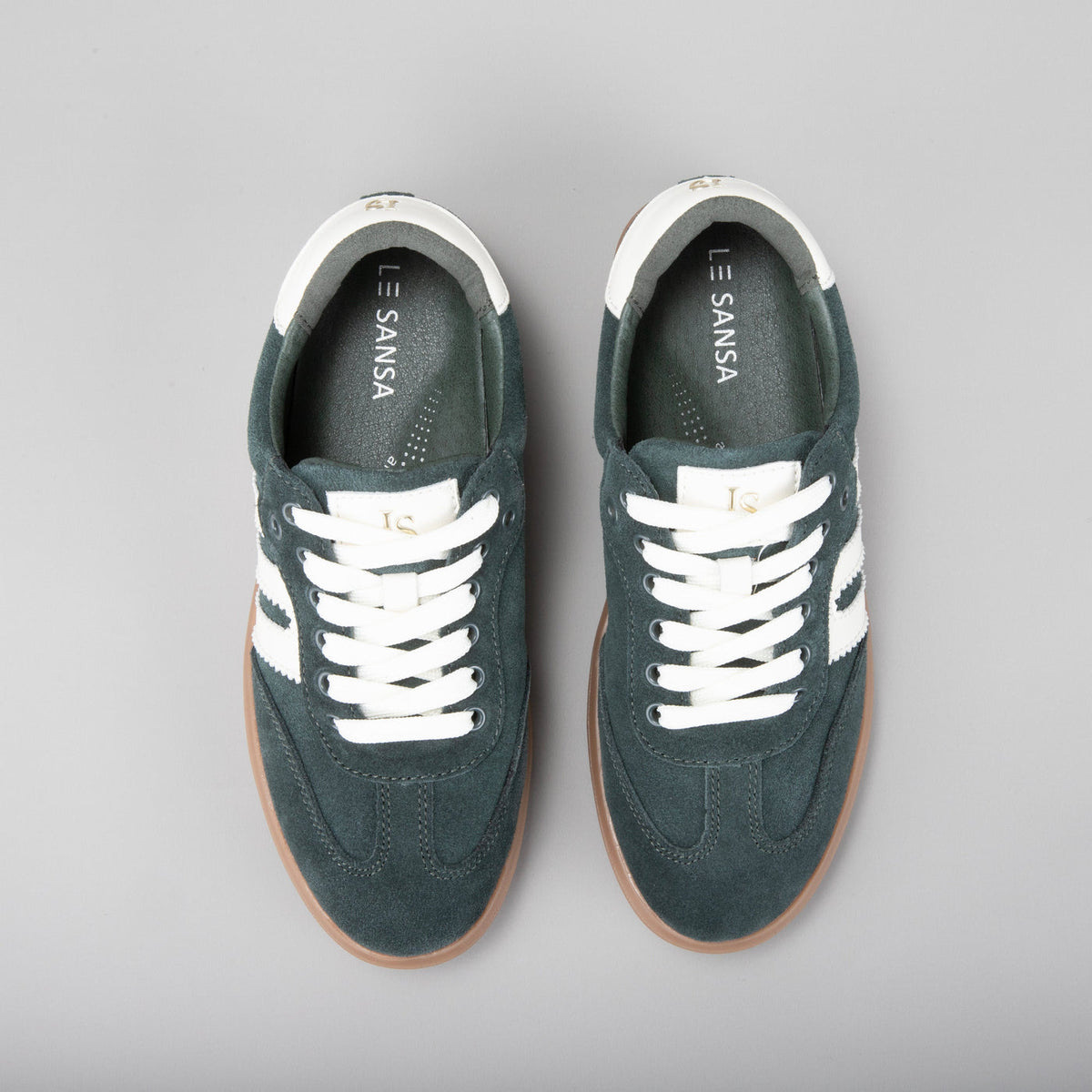 Le Sansa Juno green suede sneakers with white rubber soles and stylish laces, showcasing a modern casual footwear design.