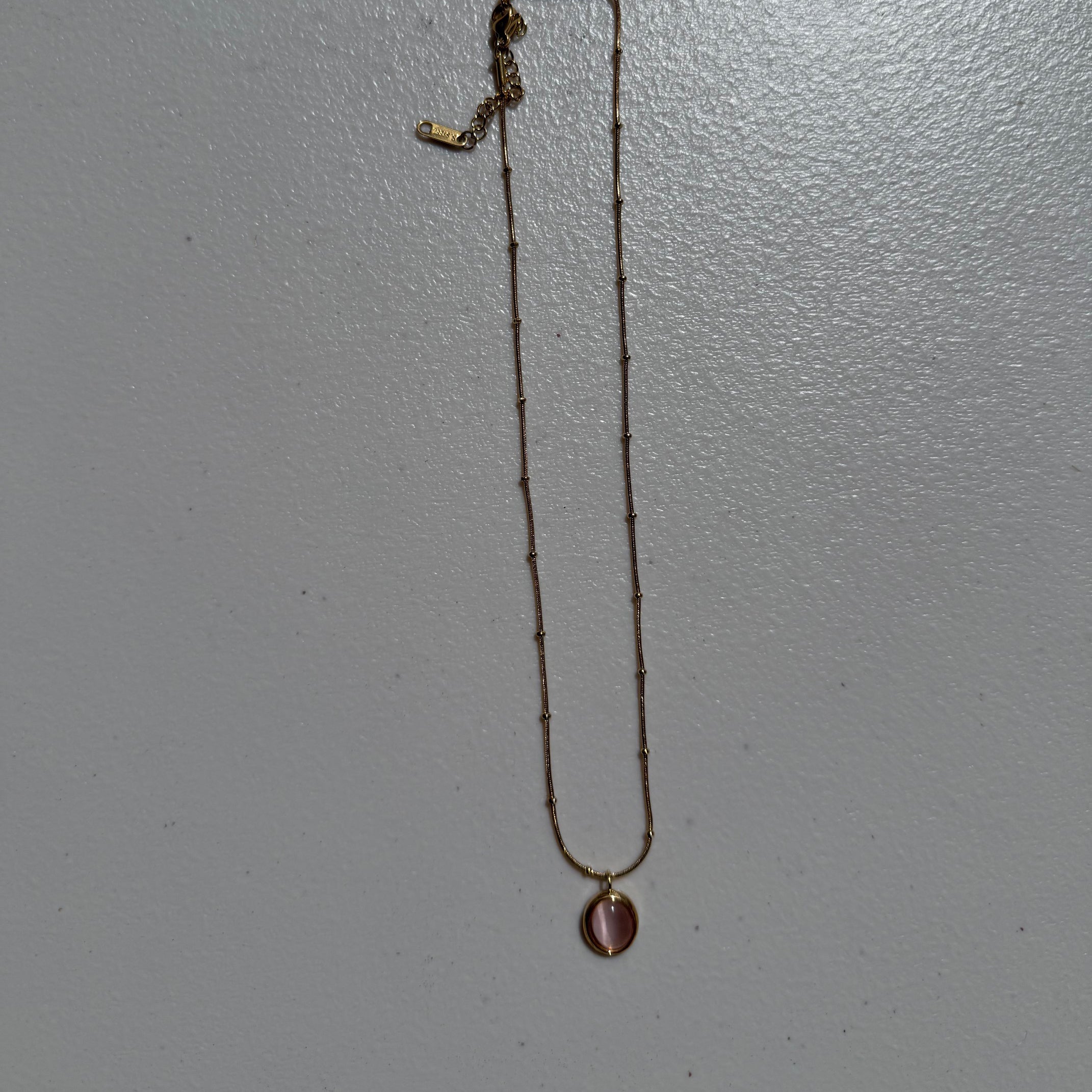 Zeke Collection blush stone pendant necklace featuring a smooth, polished blush-colored stone on a delicate chain.