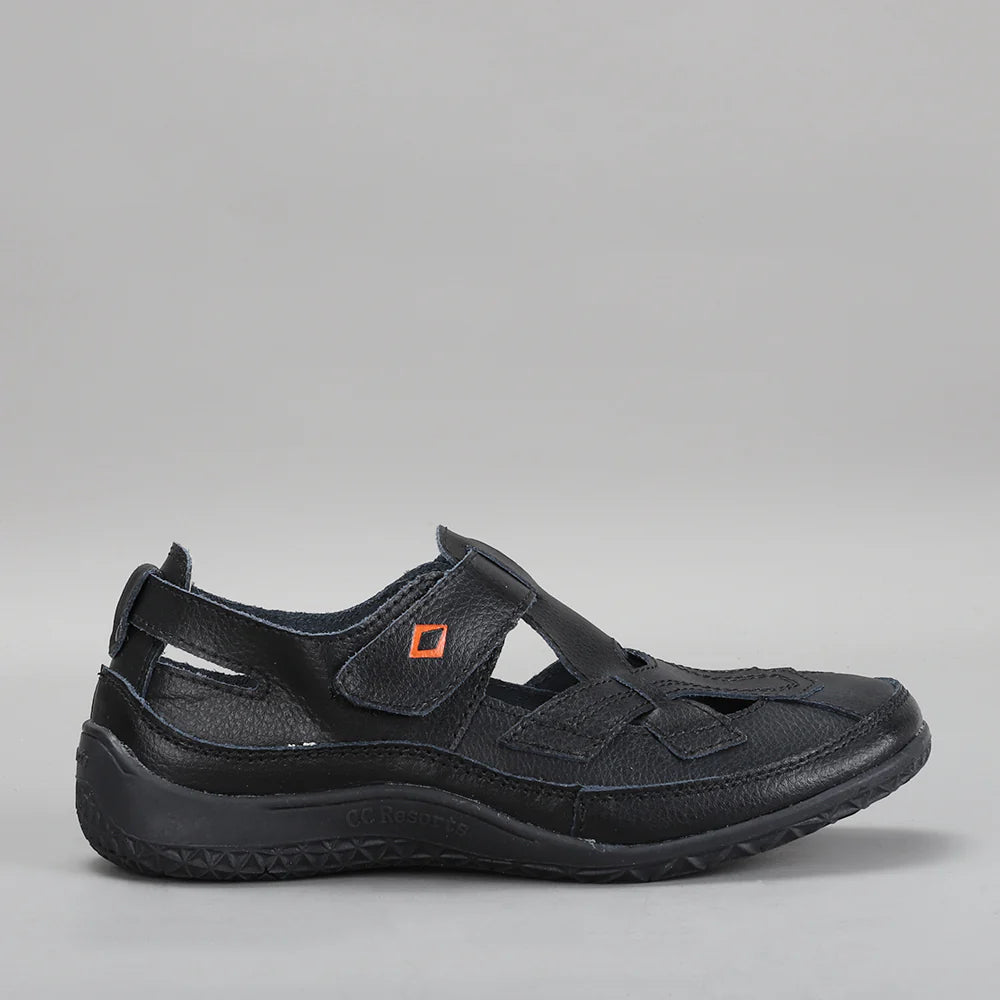 Black CC Resorts Jackie flats shown from the side, featuring a sleek slip-on design and comfortable flat sole.
