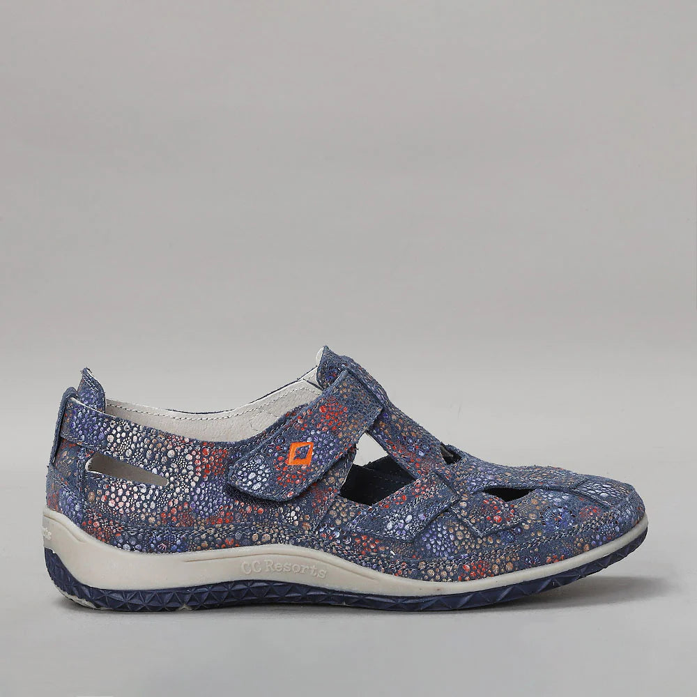 CC Resorts Jackie Indigo Flower flats shown from the side, featuring a floral pattern and comfortable slip-on design.