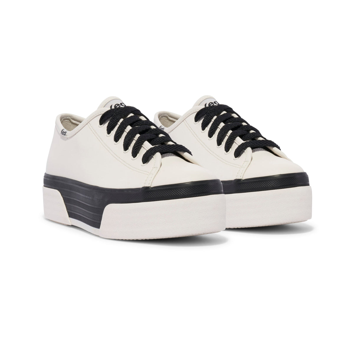 KEDS Triple Up sneakers in white and black leather, featuring a classic low-top design with white laces and black accents.