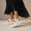White LE SANSA CENO sandals featuring sleek straps and a comfortable footbed, perfect for casual summer wear.