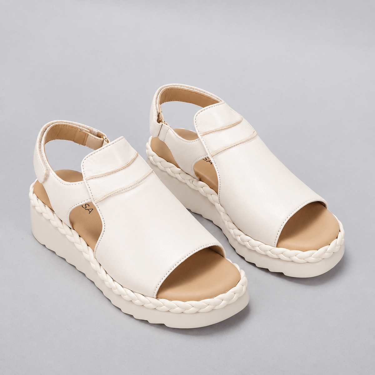 Le Sansa Emmeline cream sandals with open toes and ankle straps, featuring a stylish and comfortable design.