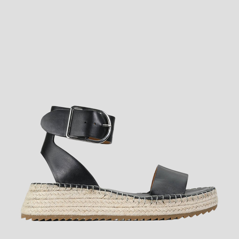 Eos Larah black sandals outdoors, featuring open-toe design and ankle straps, stylishly displayed on a natural setting.