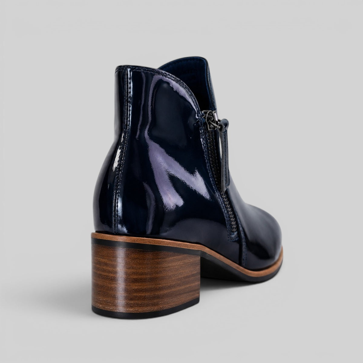 Naked Arches Oxley navy patent leather boots with sleek design and rounded toe, featuring stylish stitching and sturdy sole.