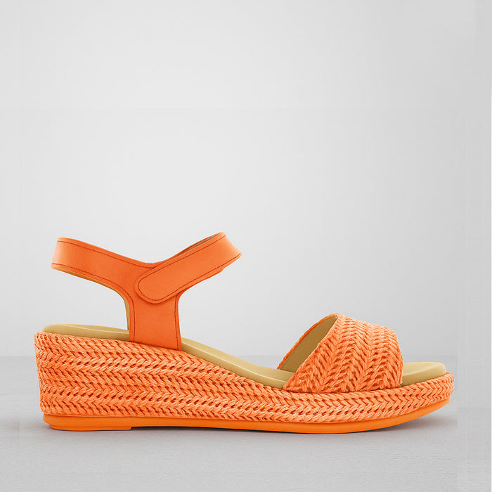Le Sansa Pilia orange sandals featuring stylish straps and a comfortable flat sole, perfect for casual summer wear.
