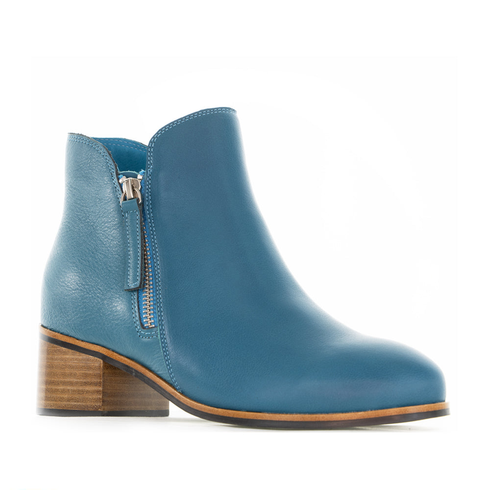 Naked Arches Oxley turquoise boots with pointed toe and ankle-high design, featuring a bold turquoise color and sleek leather finish.