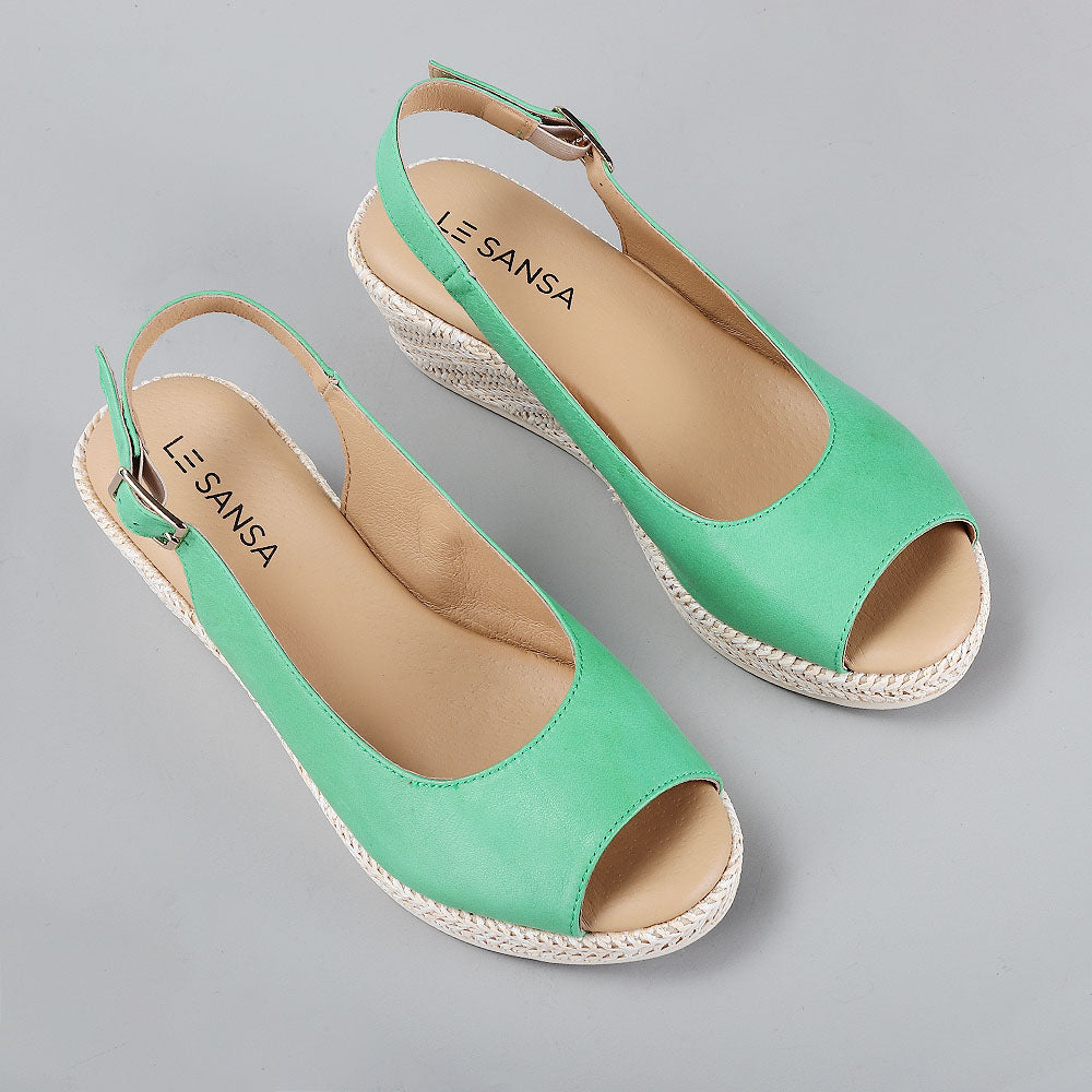 Le Sansa Petunia Fern Green sandals showing angled view of stylish, open-toe footwear with fern green straps.