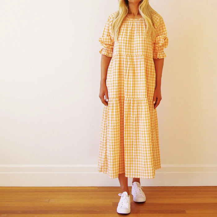 Who's Charlie Lola Gingham Dress in Mandarin, a stylish girl’s dress with a classic gingham pattern and comfortable fit.
