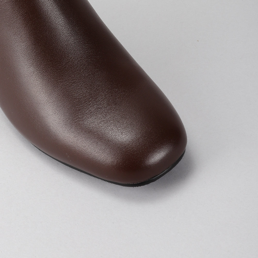 Close-up of Le Sansa Robel chocolate high boots showing smooth leather texture and sleek design.