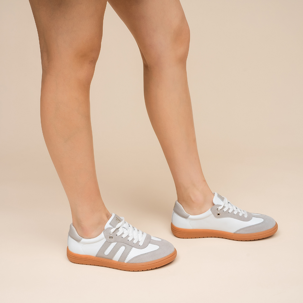 Le Sansa Juno white and light grey sneakers showing a modern design with white soles and stylish upper material.