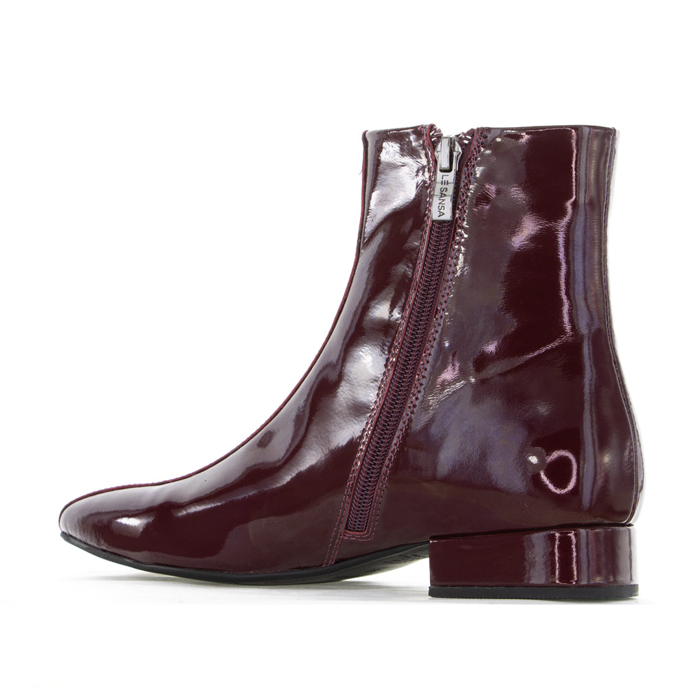 Le Sansa Sasha Merlot Patent Boots showing sleek red patent leather with a rounded toe and stylish ankle height.