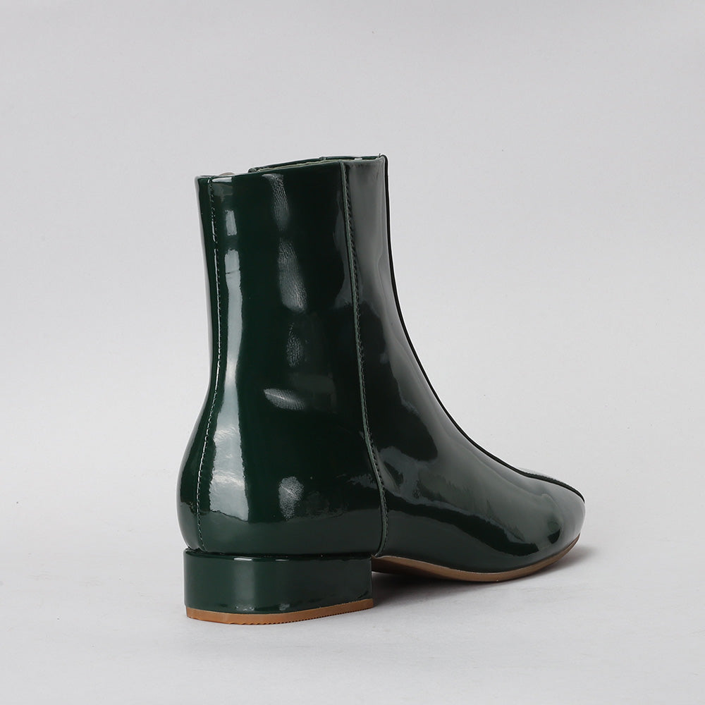 Le Sansa Sasha green patent leather boots with a sleek design and pointed toes, perfect for stylish winter footwear.
