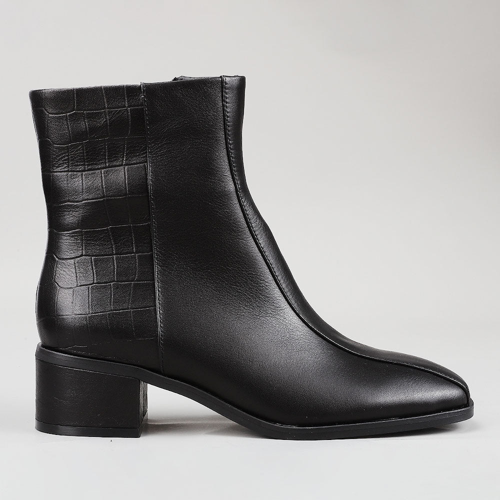 Black Le Sansa Sansa Spike boots with textured design and ankle height, featuring spike details and a sleek, modern style.