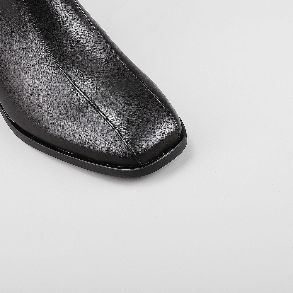 Close-up of black Le Sansa Spike boots showing the textured spike design and crocodile print details.