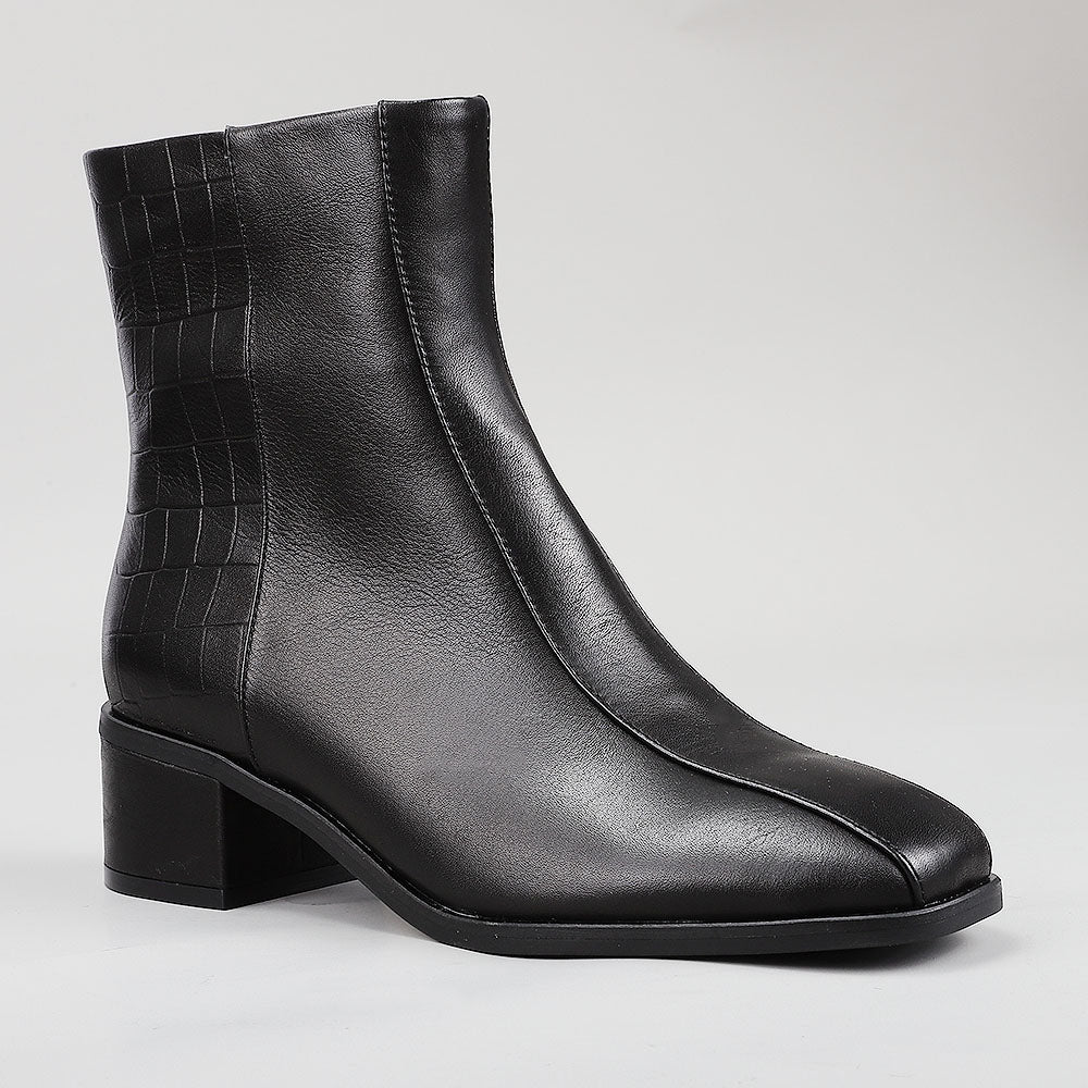 Le Sansa Spike Black boots with black leather and spike details, shown from the side with a crocodile print pattern.