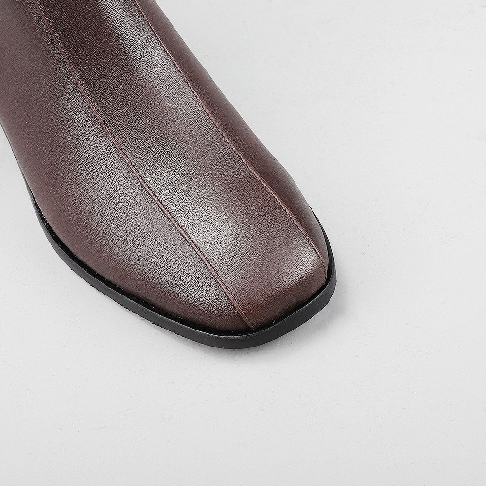 Close-up of Le Sansa Spike Choco boots showing the textured chocolate-brown leather and detailed spike embellishments.