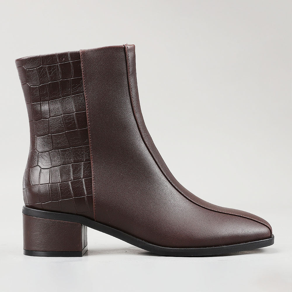 Le Sansa Spike Choco boots featuring a chocolate crocodile print design on the side, stylish and trendy footwear.