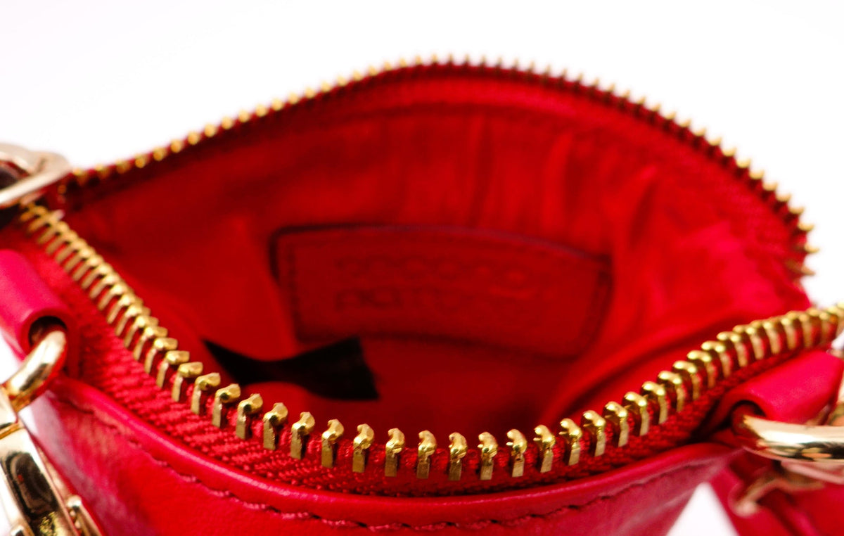Red Second Nature handbag with sleek design, featuring a textured surface and stylish handles.