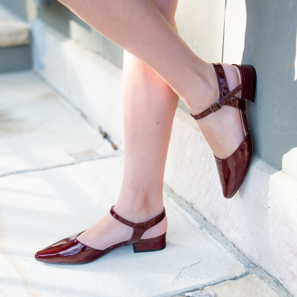 Le Sansa Coralie Merlot Patent sandals featuring glossy red patent leather straps and open-toe design.