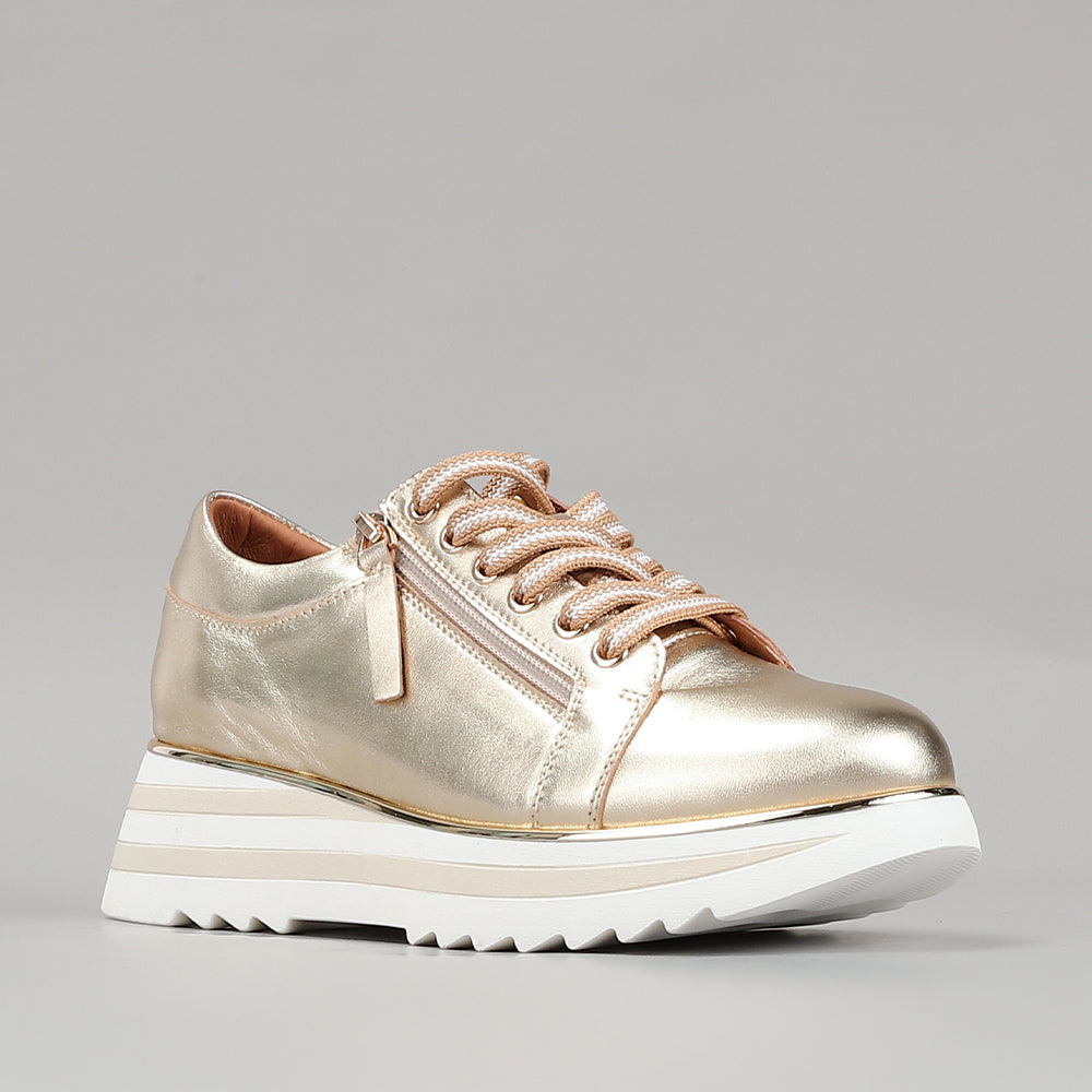 Le Sansa Skippa light gold sneakers with sleek design and white soles, displayed on a white background.