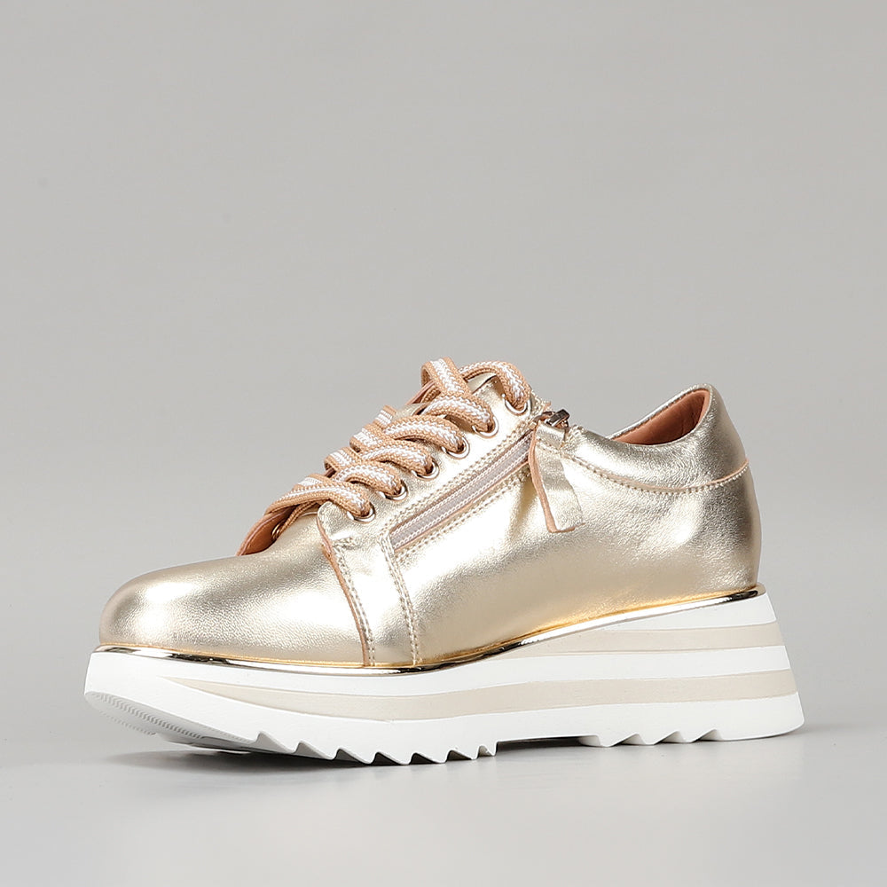 Light gold Le Sansa Skippa sneakers with sleek design and white soles, styled for casual wear and comfort.