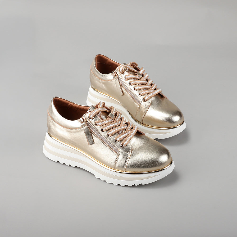 Le Sansa Skippa light gold sneakers with sleek design and white soles, stylish footwear for casual wear.