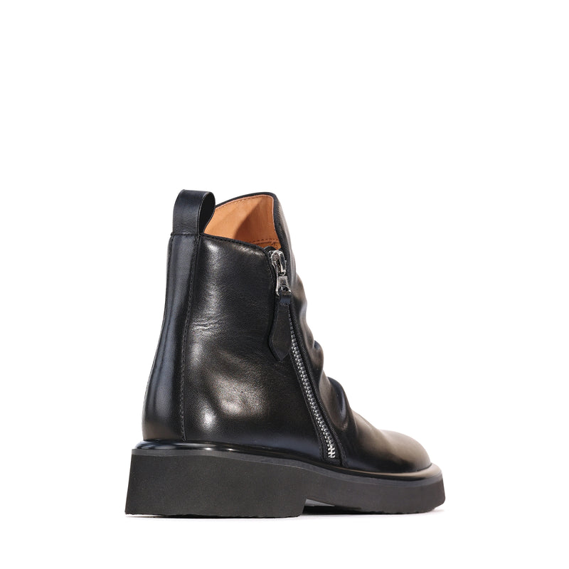 Eos Theona black boots with sleek design and ankle-height style, featuring smooth leather and subtle stitching details.