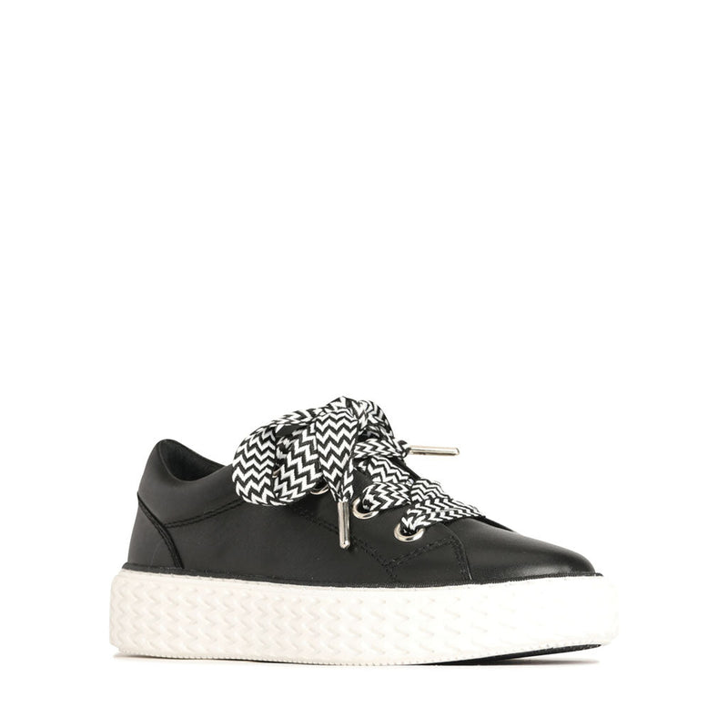 Eos Trinsic black sneakers viewed from an angle, showcasing their sleek design and modern style.