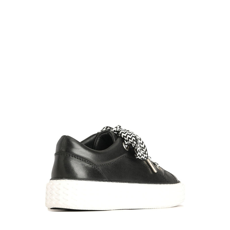 Eos Trinsic black sneakers shown from the back angle, featuring sleek design and sturdy sole.