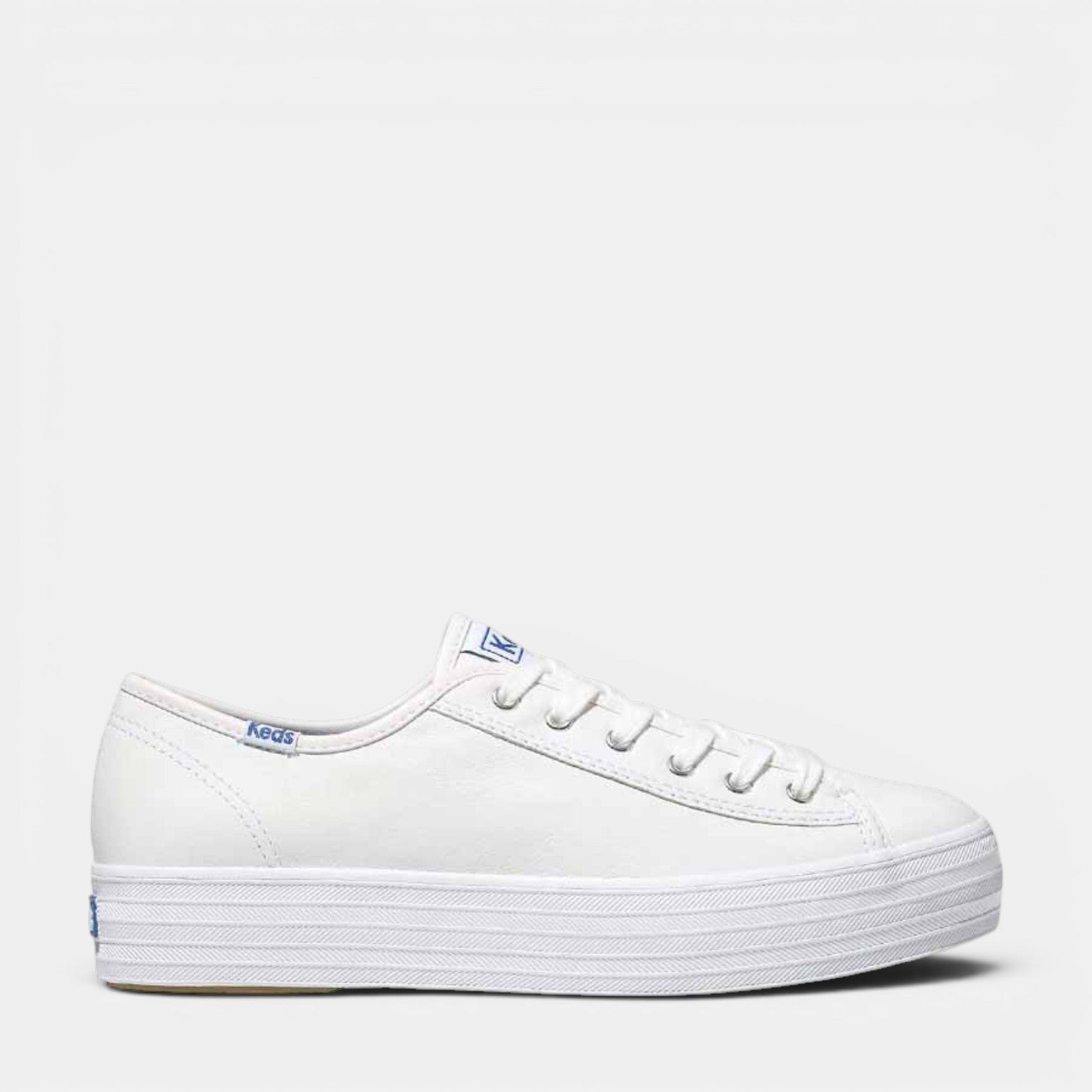 White KEDS Triple Kick sneakers with classic low-top design and white laces, showcasing clean, casual style.