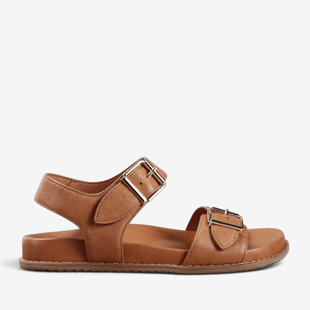 Naked Arches Ziggro tan sandals with woven strap design and open toe, displayed on neutral background.