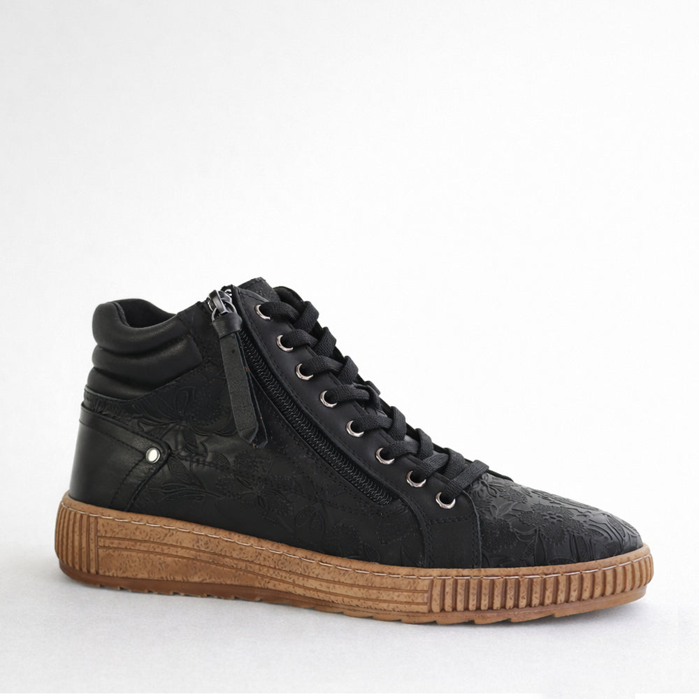 Black boho-style boots by CABELLO with lace-up design and chunky heel, featuring suede material and decorative stitching.